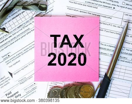 Text Tax 2020 On Note Paper With The U.s Irs 1040 Form,pen And Glasses