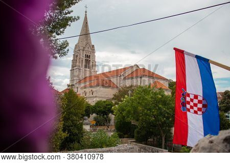 Closeup Of The Croatian Flag Waving In The Wind With The Church In The Village Of Selca, Croatia In 