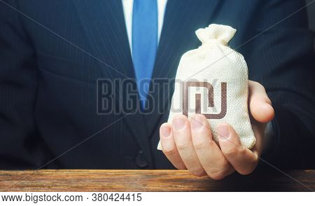 A Businessman Holds In His Hand A Israeli Shekel Money Bag. Stimulating Economic Recovery. Providing