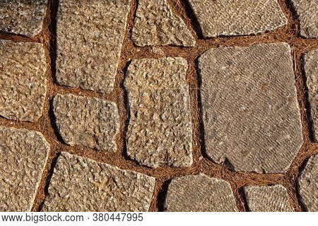 The Background Of The Floor Is Laid Out From Stones Of Various Shapes, In The Cracks Of A Needle Fro