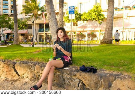 Biracial Teenage Female Tourist Resting At Waikiki Beach, Honolulu, Hawaii