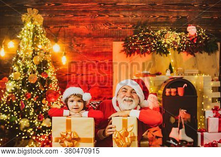 Family Holiday. Little Santa Grandfather And Grandson With Bag - Delivery Christmas Gift. Santa Help