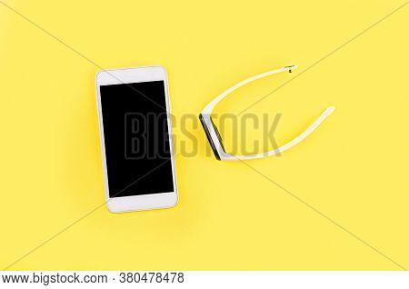 Fitness Tracker With White Braslet And Smartphone On The Yellow Background.  Concept Mobile Modern H