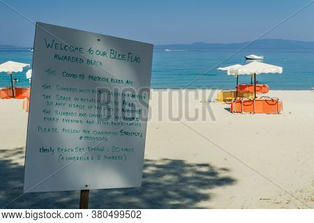 Chalkidiki, Greece - July 30 2020: Covid-19 Beach Precautions Sign. Day View Of Info At An Empty Bea