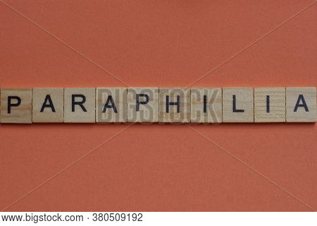 Long Word Paraphilia From Gray Wooden Small Letters With Black Font On An Orange Background