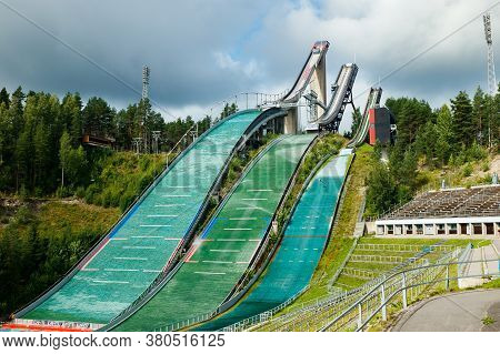 Lahti, Finland - 4 August 2020: Lahti Sports Centre With Three Ski Jump Towers. Sportsman Is Jumping