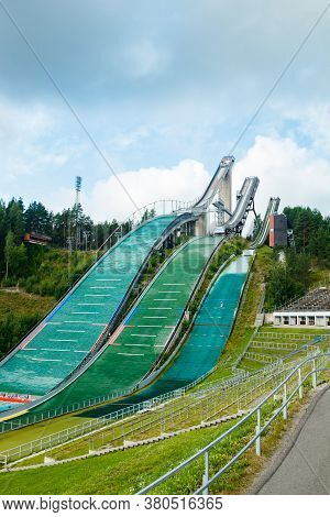 Lahti, Finland - 4 August 2020: Lahti Sports Centre With Three Ski Jump Towers. Sportsman Is Jumping