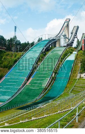 Lahti, Finland - 4 August 2020: Lahti Sports Centre With Three Ski Jump Towers. Sportsman Is Jumping