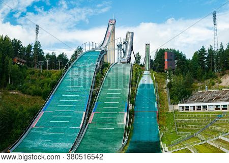 Lahti, Finland - 4 August 2020: Lahti Sports Centre With Three Ski Jump Towers. Sportsman Is Jumping