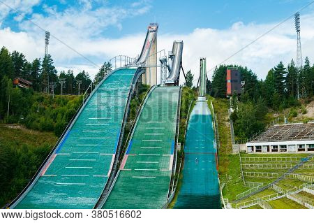 Lahti, Finland - 4 August 2020: Lahti Sports Centre With Three Ski Jump Towers. Sportsman Is Jumping