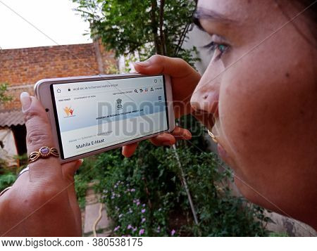 District Katni, India - 28 May 2020: An Indian Lady Holding Smart Phone With Displaying Mahila E Haa