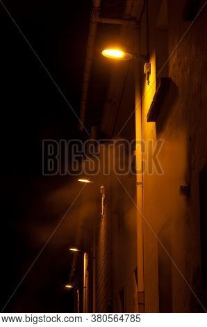 Illuminated street lights in the fog at night. Sabinanigo. Huesca. Aragon. Spain.