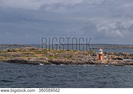 The Sea Port Sign For Passing Ships Stands On A Rocky Island In Cold Scandinavian Waters.