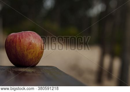 Resh Apples On Wooden Table With Lots Of Copy-space Over Blurred Background