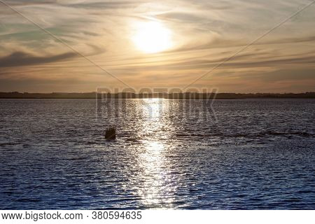 Beautiful Sunset Behind The Clouds And Blue Sky Above The Lagoon Landscape Background. Dramatic Sky 