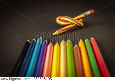 Flexible Pencil And A Set Of Colored Pencils On A Dark Background. Selective Focus