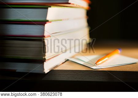 Close-up Of A Stack Of Books And A Pen With Paper For Notes. The Concept Of Home Reading Of Paper Bo