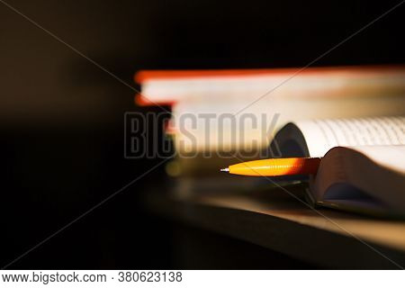 Close-up Of A Stack Of Books And A Pen With Paper For Notes. The Concept Of Home Reading Of Paper Bo