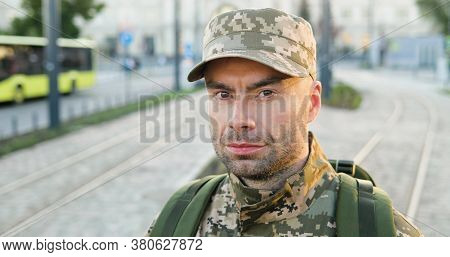 Portrait Of Happy Caucasian Handsome Young Male Soldier In Cap With Backpack Looking Brave At Street