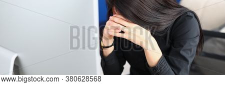 A Tired Woman Sits At The Workplace With Her Head Bowed In Front Of The Monitor. Student Upset By Di