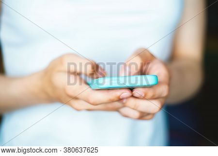 Mobile Phone In The Hands Of A Woman. Communication By Phone. The Girl Types A Text Message On Her M