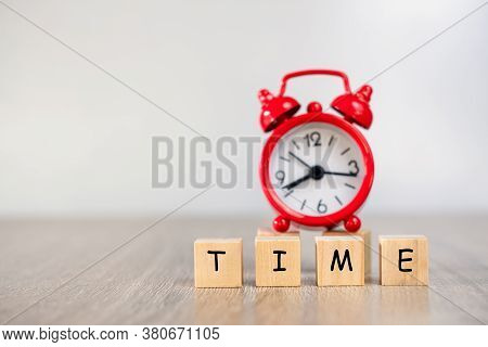 A Wooden Block That Writes The Word Time And Has A Blurred Red Alarm Clock On The Back The Concept O