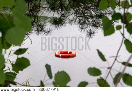 Red Lifeline In The Water. View Of The Lifeline Through The Foliage