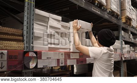 Warehouse Large Storage Or Cargo For Distribution And Man Is Picking Up A Box.