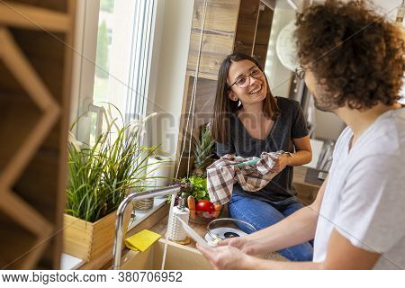 Beautiful Young Couple In Love Doing The Washing Up And Drying Together After Lunch; Couple Washing 