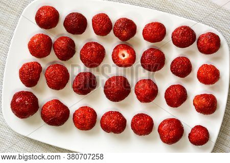 Ripe Strawberries Close-up Lie Exactly In A Row On A White Plate. One Berry Is Not Like Everything E
