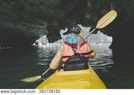 Young Beautiful Woman Floating On A Kayak In The Water Cave. The Girl Rowing The Oars On The Backgro