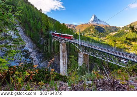 Zermatt, Switzerland. Gornergrat Red Tourist Train On The Bridge And Matterhorn Peak Panorama In Swi