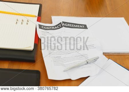 The Torn Contract Paper Placed On The Table After Negotiation Fails. The Concept Of Contract Termina