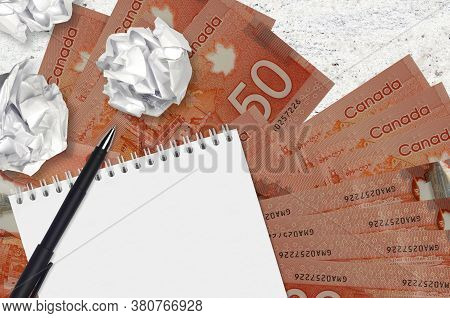 50 Canadian Dollars Bills And Balls Of Crumpled Paper With Blank Notepad. Bad Ideas Or Less Of Inspi
