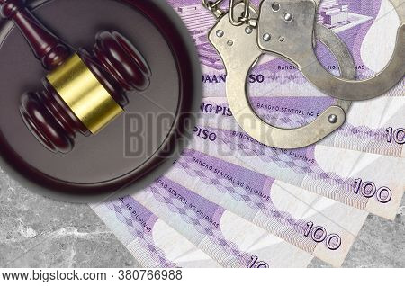 100 Philippine Piso Bills And Judge Hammer With Police Handcuffs On Court Desk. Concept Of Judicial 