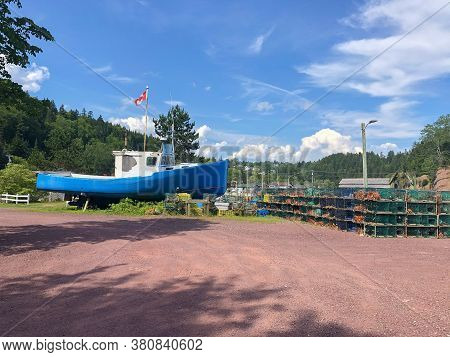 Blue Fishing Boats Lobster Traps In Different Colors Along A Wharf In Atlantic Canada On The Bay Of 