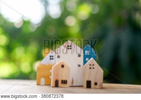 Closed Up Tiny Home Model On Floor Or Wood Board With Sunlight Green Bokeh Background. House Propert