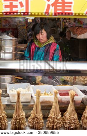Luoyang, Henan Province / China - January 3, 2016: Vendor Girl Selling Snacks At A Street Food Stall