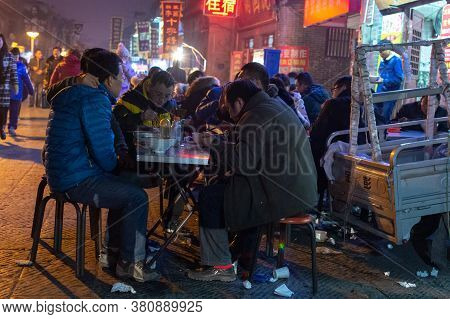 Luoyang, Henan Province / China - January 3, 2016: People Dining At An Improvised Street Food Stall 