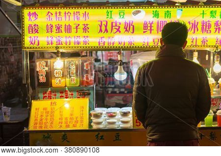 Luoyang, Henan Province / China - January 3, 2016: Man Buying Snacks At A Street Food Stall In Luoya