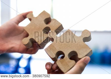 Woman Trying Connect Wooden Jigsaw Puzzle Piece. Concept Of Business Strategy In Teamwork For Soluti