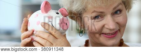 Portrait Of Senior Charming Woman Holding Piggy-bank. Elderly Female And Ceramic Container For Coins