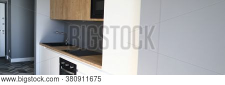 Close-up Of Kitchen Furniture In New Luxury Apartment. Room With Modern Interior Design. Black Sink 