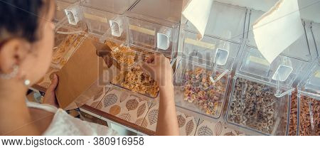 Young Woman Filling Up Reusable Bag With Pasta, Nuts Or Grains In Zero Waste Plastic Free Store. Low