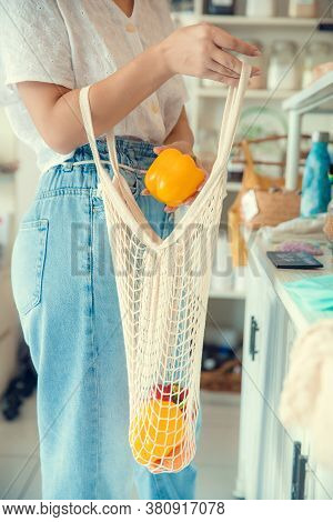 Woman Hand Holding String Shopping Bag With Vegetables And Fruits In Eco Shop. Vegetables In Eco-fri