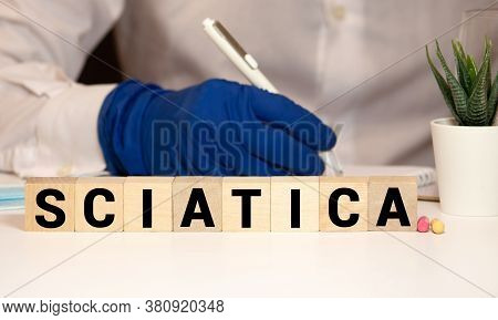 Word Sciatica From White Blocks And Red Circle Dot On Dark Fabric Background. Orthopedics, Neurology