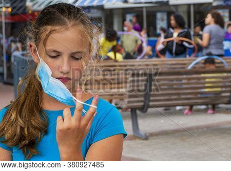 A Young Girl Wears A Face Mask On The Streets Of The City.cute Teenage Girl With A Surgical Mask On 
