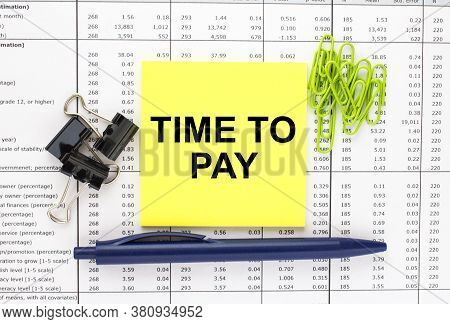 Text Time To Pay On Financial Tables With Pen And Paper Clips