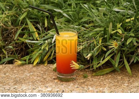 Glass Of Orange Juice With Syrup In A Glass On A Green Background, Two-color