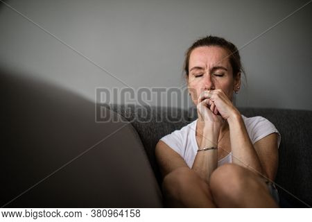 Depressed mid-aged woman at home feeling sad, lonely, anxious (color toned image)